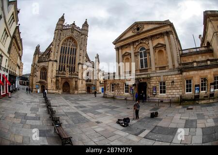 Ein Buscher spielt auf einem leeren Platz vor Bath Abbey und den römischen Bädern, nachdem die Regierung strengere Maßnahmen zur Bekämpfung von Coronavirus angekündigt hatte. Stockfoto