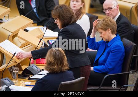 Edinburgh, Großbritannien. März 2020. Abgebildet: (In Schwarz) Jeane Freeman MSP - Kabinettsministerin für Gesundheit und Sport; (in Blau), Nicola Sturgeon MSP - erste Ministerin Schottlands und Leiterin der Scottish National Party (SNP). Ministererklärung: Roman Coronavirus COVID-19 Update Credit: Colin Fisher/Alamy Live News Stockfoto