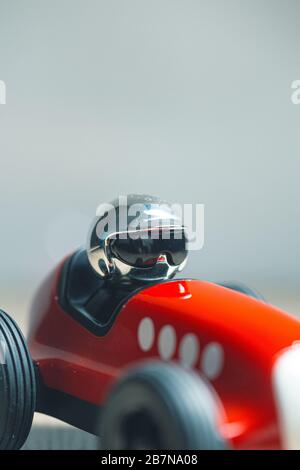 Silberfarbener, heller Helm auf einem roten Oldtimer Stockfoto