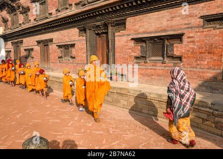 Bhaktapur, Nepal - 28. Januar 2020: Junge buddhistische Mönch, die in Morgenalmen in Bhaktapur auf Nepal spazieren gehen Stockfoto