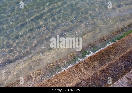 Sauberes Wasser mit Zementtreppe, kristallklarem Meerwasser und erstklassiger Sauberkeit, sehen Sie Felsen auf dem Grund des Meeres Natur Ozean, unter Wasser am Strand Stockfoto