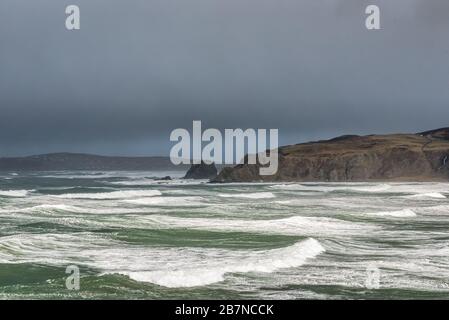 Hohe Winde und schwarze Sturmwolken erzeugen raue Meere der Küste von Donegal in Irland Stockfoto