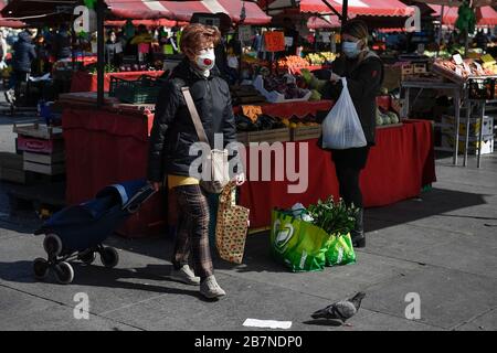 Turin, Italien. März 2020. TURIN, ITALIEN - 17. März 2020: Eine Frau, die eine Atemmaske trägt, kauft Lebensmittel im Freiluftmarkt Porta Palazzo. Die italienische Regierung hat beispiellose Einschränkungen auferlegt, um die Ausbreitung des COVID-19-Coronavirus-Ausbruchs zu stoppen, und andere Maßnahmen, die die Bewegungen der Menschen nur für die Arbeit, für den Kauf wesentlicher Waren und aus gesundheitlichen Gründen erlaubt sind. (Foto von Nicolò Campo/Sipa USA) Credit: SIPA USA/Alamy Live News Stockfoto