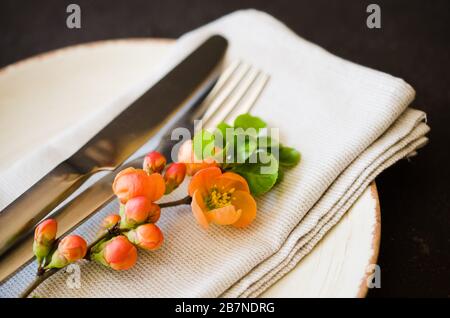 Jahrgang Tabelle mit zarten Blüten auf einer Leinwand Serviette auf einem dunklen Hintergrund, close-up. Urlaub Tabelle mit floralem Dekor Stockfoto
