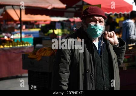 Turin, Italien. März 2020. TURIN, ITALIEN - 17. März 2020: Ein Mann, der eine Atemmaske trägt, kauft Lebensmittel im Freiluftmarkt Porta Palazzo. Die italienische Regierung hat beispiellose Einschränkungen auferlegt, um die Ausbreitung des COVID-19-Coronavirus-Ausbruchs zu stoppen, und andere Maßnahmen, die die Bewegungen der Menschen nur für die Arbeit, für den Kauf wesentlicher Waren und aus gesundheitlichen Gründen erlaubt sind. (Foto von Nicolò Campo/Sipa USA) Credit: SIPA USA/Alamy Live News Stockfoto