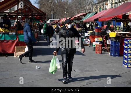 Turin, Italien. März 2020. TURIN, ITALIEN - 17. März 2020: Ein Mann, der eine Atemmaske trägt, kauft Lebensmittel im Freiluftmarkt Porta Palazzo. Die italienische Regierung hat beispiellose Einschränkungen auferlegt, um die Ausbreitung des COVID-19-Coronavirus-Ausbruchs zu stoppen, und andere Maßnahmen, die die Bewegungen der Menschen nur für die Arbeit, für den Kauf wesentlicher Waren und aus gesundheitlichen Gründen erlaubt sind. (Foto von Nicolò Campo/Sipa USA) Credit: SIPA USA/Alamy Live News Stockfoto