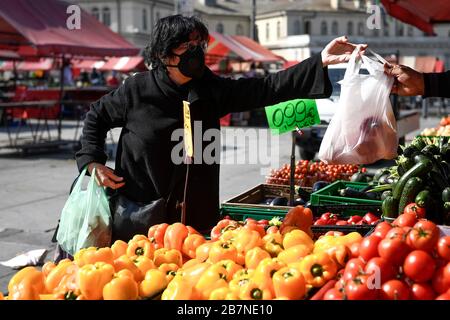 Turin, Italien. März 2020. TURIN, ITALIEN - 17. März 2020: Eine Frau, die eine Atemmaske trägt, kauft Lebensmittel im Freiluftmarkt Porta Palazzo. Die italienische Regierung hat beispiellose Einschränkungen auferlegt, um die Ausbreitung des COVID-19-Coronavirus-Ausbruchs zu stoppen, und andere Maßnahmen, die die Bewegungen der Menschen nur für die Arbeit, für den Kauf wesentlicher Waren und aus gesundheitlichen Gründen erlaubt sind. (Foto von Nicolò Campo/Sipa USA) Credit: SIPA USA/Alamy Live News Stockfoto