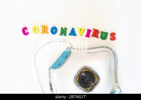 Corona-Viruswort mit Buchstaben auf weißem Hintergrund mit Schutzmaske für medizinische Zwecke. Schutz vor Infektionen und Bakterien. Coronavirus Stockfoto