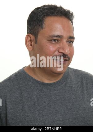 Ein Indianermann in einem Studio vor einem weißen Hintergrund, der wegschaut Stockfoto