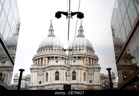 Die St. Paul's Cathedral spiegelte sich am Tag in einem Fenster wieder, nachdem Premierminister Boris Johnson die Menschen dazu aufforderte, sich von Kneipen, Clubs und Theatern fernzuhalten, möglichst von zu Hause aus zu arbeiten und alle nicht notwendigen Kontakte zu vermeiden und zu reisen, um die Auswirkungen der Coronavirus Pandemie zu verringern. Stockfoto