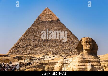 Gizeh, Ägypten - 23. Dezember 2019: Die große Sphinx von Gizeh und im Hintergrund die Pyramide von Khafre, die von Touristen aus der ganzen Welt besucht wird Stockfoto