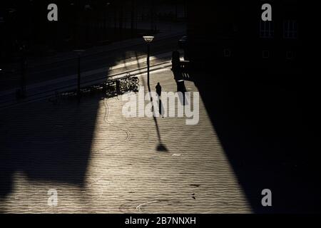 Kopenhagen, Dänemarks Hauptstadt, Silhouetten langer Schatten über dem Rathausplatz bei Sonnenaufgang Stockfoto