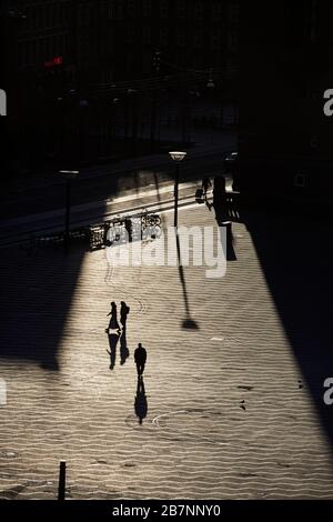 Kopenhagen, Dänemarks Hauptstadt, Silhouetten langer Schatten über dem Rathausplatz bei Sonnenaufgang Stockfoto