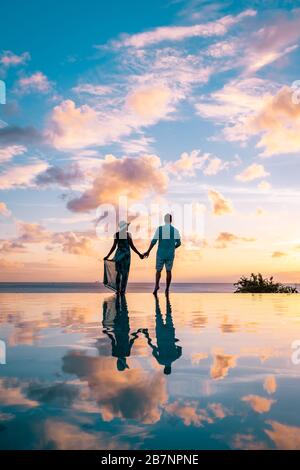 Ein Paar im Urlaub auf der tropischen Insel St. Lucia, Männer und Frauen, die den Sonnenuntergang in der Saint Lucia Caribbean beobachten Stockfoto