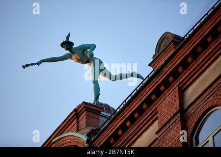 Kopenhagen, Dänemarks Hauptstadt, die Merkurstatue von Julius Schultz übergibt auf dem Dach eines Gebäudes in Købmagergade eine Blume Stockfoto