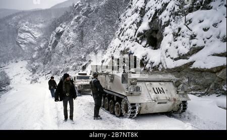 21. Januar 1994 während des Krieges in Zentralbosnien: Der Journalist Anthony Loyd von The Times geht an einem FV432 der British Army der Coldstream Guards nördlich von Gornji Vakuf vorbei. Stockfoto