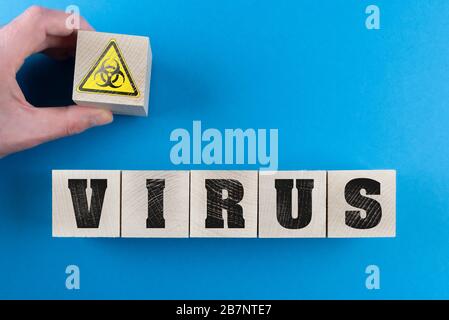 Word VIRUS und Biohazard Symbol auf Holzwürfeln, Corona Virus Kovid-19 Ausbruch Warnkonzept Stockfoto