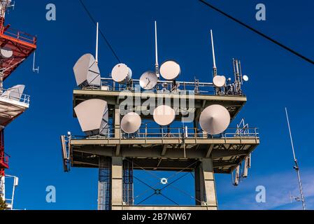 Haufen mobiler Sender auf einer Turmspitze am Schockl Berg in Graz. Drahtloses Technologiekonzept. Stockfoto