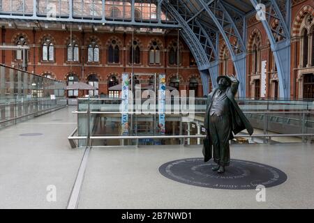 Da die britische Regierung eindringlich darauf drängte, dass alle Briten nicht unbedingt ins Ausland reisen sollten, um die Pandemie von Coronavirus in Großbritannien zu bekämpfen, blickt die Statue des Dichters John Betjeman (2007) von Martin Jennings auf einem ungewöhnlich ruhigen Konkurs im Bahnhof St. Pancras hin, Die Londoner Endstation für Eurostar-Dienste auf dem europäischen Festland, am 17. März 2020, in London, England. Stockfoto