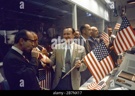 Apollo 11 - NASA, 1969. NASA- und MSC-Beamte schlossen sich mit Fluglotsen zusammen, um den erfolgreichen Abschluss der Lunar Landing Mission Apollo 11 im Mission Control Center zu feiern. Von links Dr. Maxime A. Faget, MSC Director of Engineering and Development; George S. Trimble, MSC Deputy Director; Dr. Christopher C. Kraft Jr., MSC Director für Flight Operations; Julian Scheer (hinten), Assistant Adminstrator, Office of Public Affairs, NASA HQ.; George M. Low, Manager, Apollo Space-Programm, MSC; Dr. Robert R. Gilruth, MSC-Direktor, und Charles W. M. Stockfoto