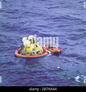 Apollo 11 - NASA, 1969. Die Besatzung von Apollo 11 erwartet die Abholung mit einem Hubschrauber von der USS Hornet. Der vierte Mann im Leben Floß ist ein Schwimmer des Unterwasser-Abbruchteams der United States Navy. Alle vier Männer tragen biologische Isolierungskleidung. Das Apollo 11 Command Module Columbia mit den Astronauten Neil Armstrong, Michael Collins und Buzz Aldrin an Bord landete um 11:49 Uhr CDT, 24. Juli 1969 auf See.