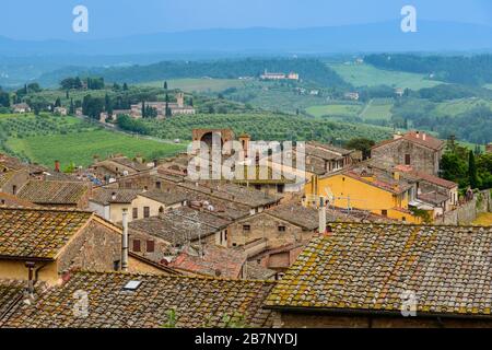 Dächer von San Gimignano, toskanische Landschaft mit sanften Hügeln und Santa Maria Assunta a Monte Oliveto Minore aus Parco della Rocca, San Gimignano Stockfoto