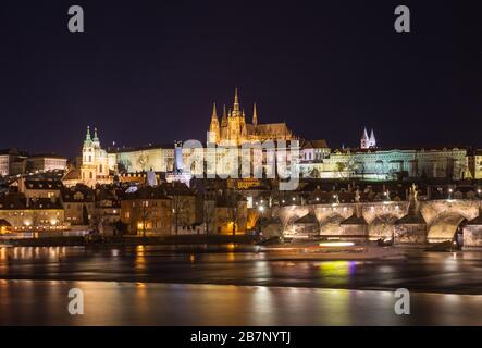 Prager Stadtbild in der Nacht. Blick auf die beleuchtete Prager Burg mit dem Veitsdom und der Karlsbrücke über die Moldau Stockfoto