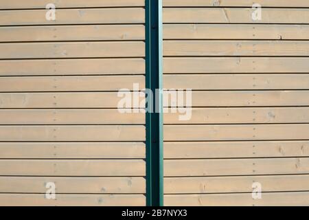 Holz-Textur-Hintergrund mit Bohlen und grünem Metallstab bei Sonnenlicht Stockfoto