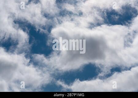 Sonniger Tag, schöne, helle, flauschige Wolken gegen den blauen Himmel, weicher Fokus. Stockfoto