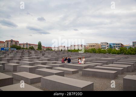 Ein Blick auf das Denkmal für die ermordeten Juden Europas mit Touristen, die auf Säulen sitzen Stockfoto