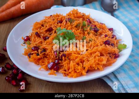 Salat mit Karotten- und Granatapfelsamen mit Cilantro-Topping. Gesunder Snack, reich an Antioxidantien. Verwendung für das Gesundheitskonzept. Stockfoto