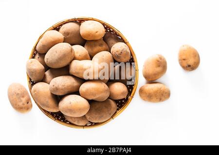 Healthy Food Concept Bio-Rohkartoffeln im Bambuskorb isoliert auf weißem Grund Stockfoto