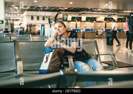 Verärgert oder gelangweilt Mädchen Touristen oder Studenten am Flughafen. Ihr Flug war verspätet oder sie war müde. Stockfoto