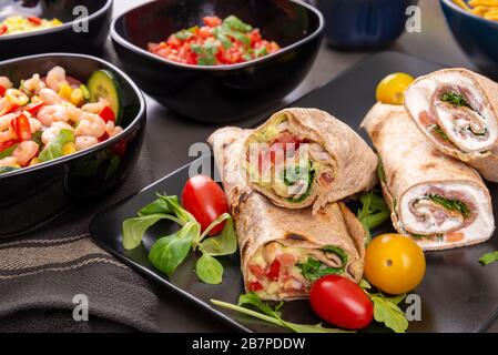 Verschiedene gemischte mexikanische Gerichte. Tortillas mit Fleisch und Guacamol und Garnelensalat Stockfoto