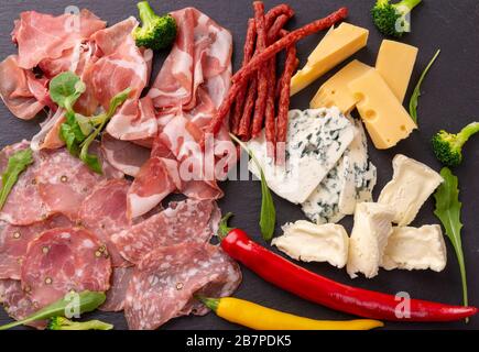 Verschiedene Vorspeisen auf einem Schieferteller. Schinken, Käse und Wurst. Ansicht von oben Stockfoto