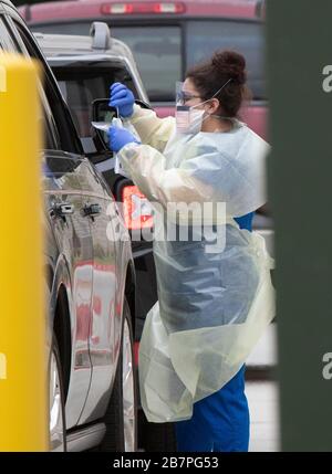 Medizinische Fachkräfte bewerten und tupfen von einem ständigen Strom besorgter Texaner in einer Baylor Scott & White Drive-in-Klinik in Austin, Texas. Texas schränkt die öffentlichen Versammlungen weiter ein, als diese Woche eine enorme Zunahme der COVID-19-Fälle mit Schließung von Bars und Restaurants zu verzeichnen ist. Credit: Bob Daemmrich/Alamy Live News Stockfoto