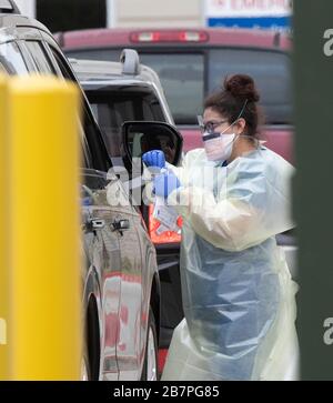 Medizinische Fachkräfte bewerten und tupfen von einem ständigen Strom besorgter Texaner in einer Baylor Scott & White Drive-in-Klinik in Austin, Texas. Texas schränkt die öffentlichen Versammlungen weiter ein, als diese Woche eine enorme Zunahme der COVID-19-Fälle mit Schließung von Bars und Restaurants zu verzeichnen ist. Credit: Bob Daemmrich/Alamy Live News Stockfoto