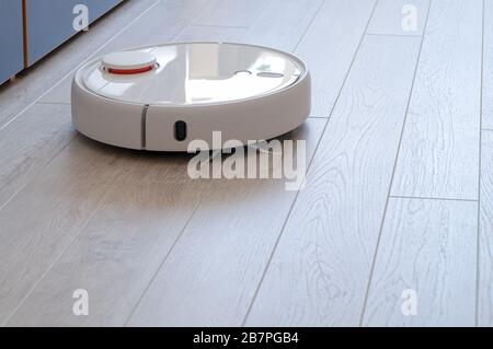 Roboter-Staubsauger auf Holz Laminatboden smart Reinigungstechnik Stockfoto