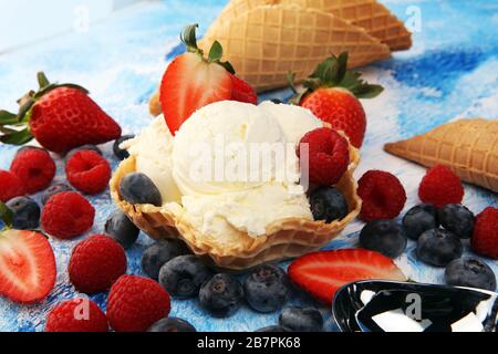 Vanilleeis schaufelt mit frischen Beeren auf dem Tisch Stockfoto