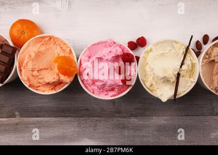 Verschiedene Eiscreme mit frischen Blaubeeren, Erdbeeren, Himbeere, Schokolade, Vanille auf rustikalem Hintergrund. Sommer und süßes Eis Stockfoto