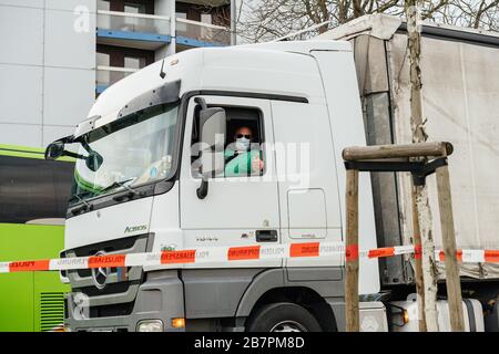 Kehl, Deutschland - 16. März 2020: Lkw-Fahrer in Mercedes-Benz Actros mit Schutzmaske zeigt OK-Zeichen beim Grenzübergang Strasbourg Kehl Krisenmaßnahmen gegen das neuartige Coronavirus Stockfoto