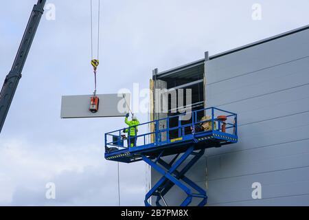 Sandwichpaneele Wandmontage mit Kran und Scherenhub Stockfoto