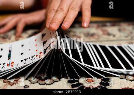 Eine Person, die ein Band macht, breitete sich mit seinen Spielkarten aus Stockfoto