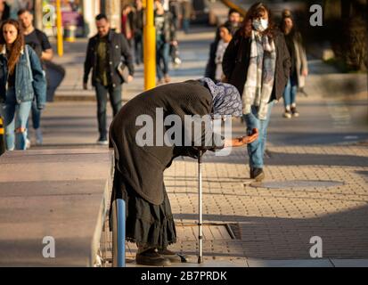 Alte Bettler-Seniorin in schwarzer Kleidung und mit einem Stock bettelt seit 2020 auf den Straßen in Sofia, Bulgarien, um Geld Stockfoto