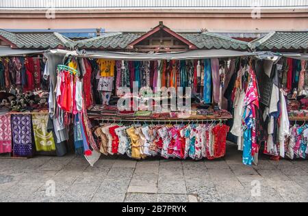 Guilin, China - 10. Mai 2010: Stadtzentrum. Straßenmarkt mit halbautomatischen Ständen mit grünen Dächern, auf denen bunte Kleidungsstücke angeboten werden Stockfoto