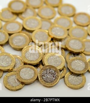 LONDON, Großbritannien - JANUAR 2020: Nahaufnahme der britischen Währung Great British Pound GBP - eine Pound-Münze, die sich auf andere Münzen stützt, verschwommen im Hintergrund Stockfoto