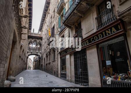 Die gothische Brücke des monumentalen Komplexes des Palastes von Generalitat mit der Straße, die während der Pandemie des Corona-Virus verlassen wurde.die Bewohner von Barcelona sehen sich dem dritten Tag der Hauseinschließung mit den Straßen ausgesetzt, die aufgrund der Bedrohung durch das Coronavirus fast leer sind. Stockfoto