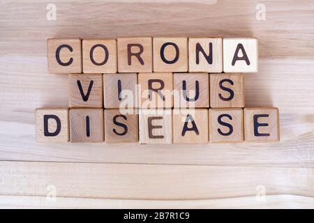 Die Aufschrift Corona Virus disease on a Holzhintergrund, Draufsicht. Die Epidemie des Kovid-19-Virus. Holzwürfel mit Buchstaben. Stockfoto