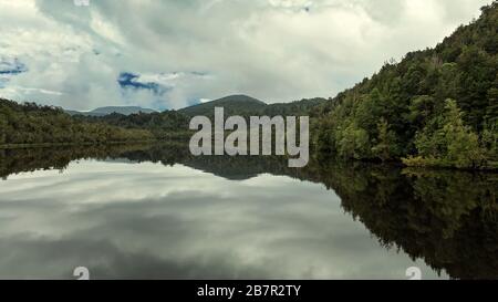 Reflexionen des Waldes auf dem ruhigen Wasser des Gordon River in Tasmanien, Australien. Farbtonierung im Kino. Stockfoto
