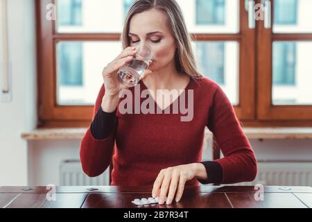 Frau, die sich krank oder unwohl fühlt und Medikamente nimmt Stockfoto